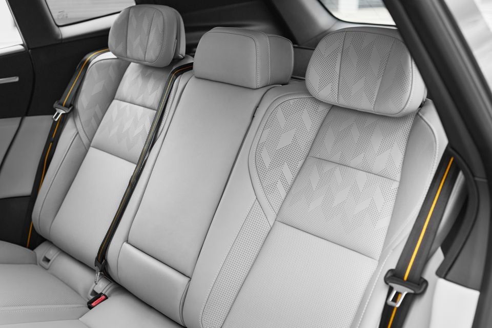 Light grey perforated leather rear seats with yellow-striped seatbelts inside the 2027 Polestar 4 SUV