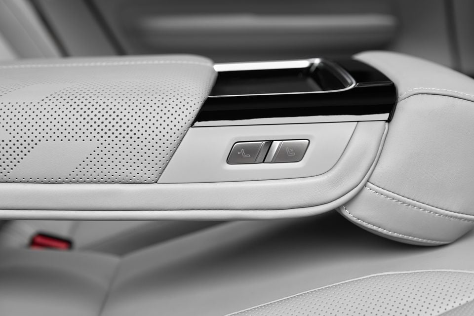Light grey perforated leather armrest with seat recline buttons in the rear seat of a 2027 Polestar 4 SUV