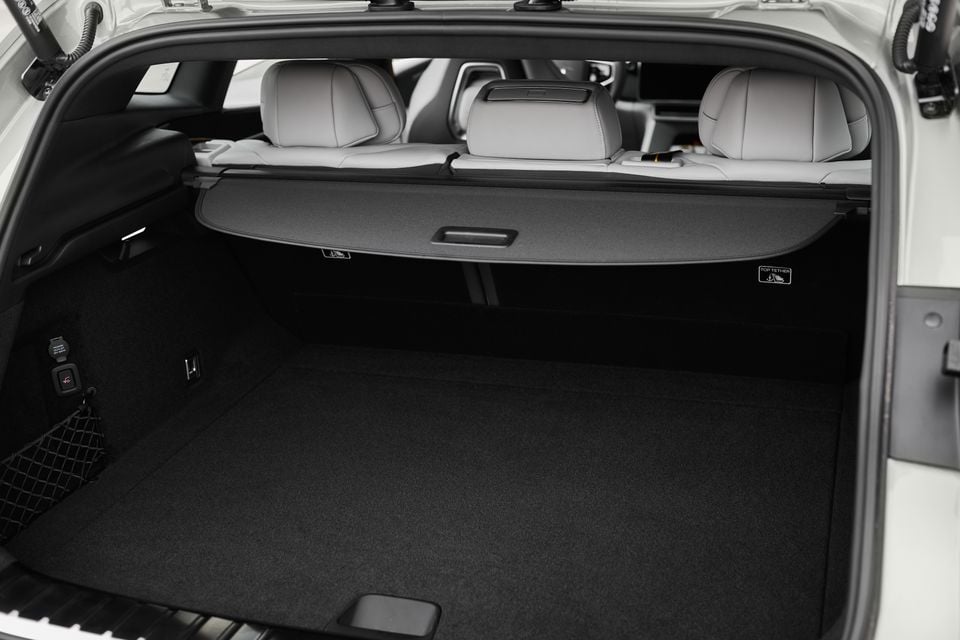 Boot of a 2027 Polestar 4 SUV with the tailgate open, showing a black carpeted cargo area, cargo cover and grey rear seats