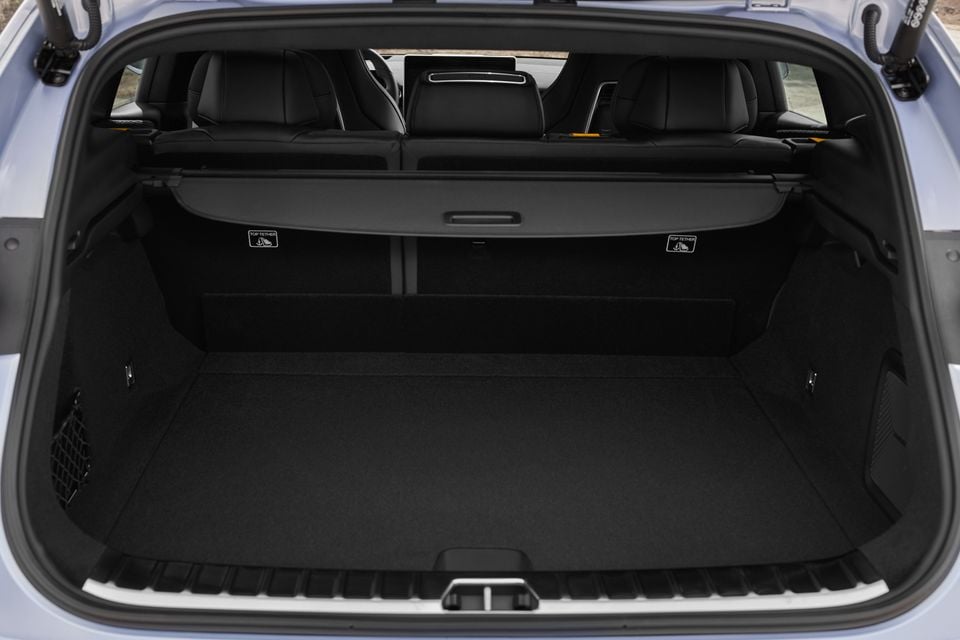 The boot of a 2027 Polestar 4 SUV with the tailgate open, showing a carpeted cargo floor, cargo cover and black rear seats