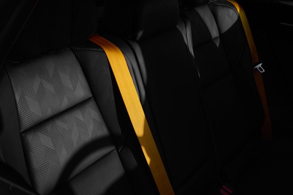 Black perforated leather seats with bright yellow seatbelts inside the 2027 Polestar 4 Performance SUV
