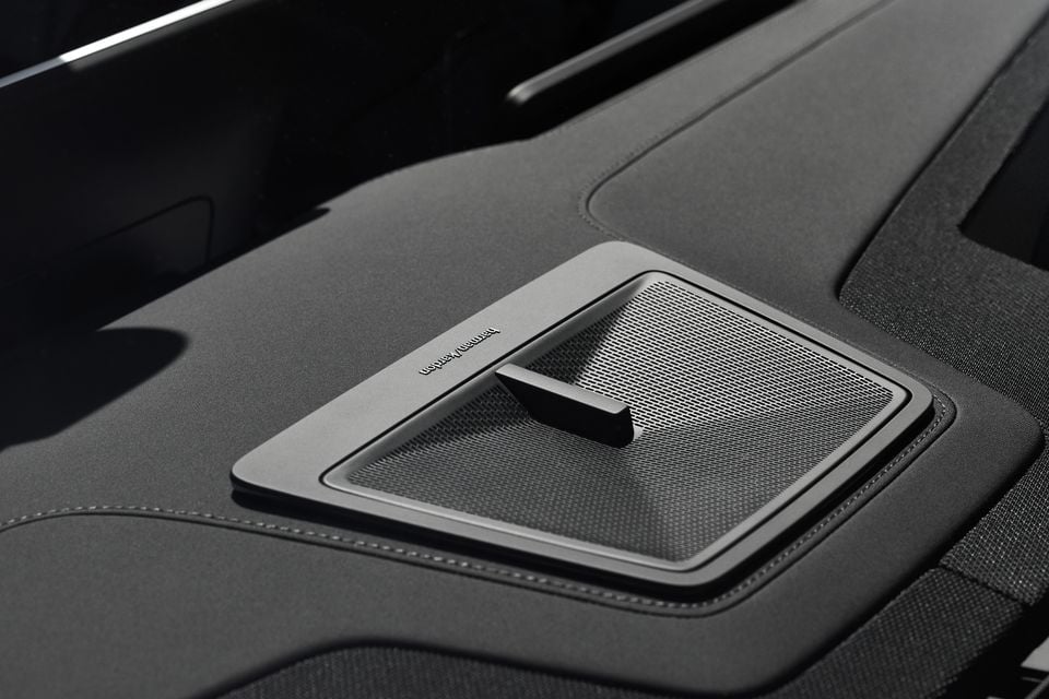 Close-up of a Harman Kardon speaker grille with a fin-shaped tweeter on the rear parcel shelf of a 2027 Polestar 4 SUV