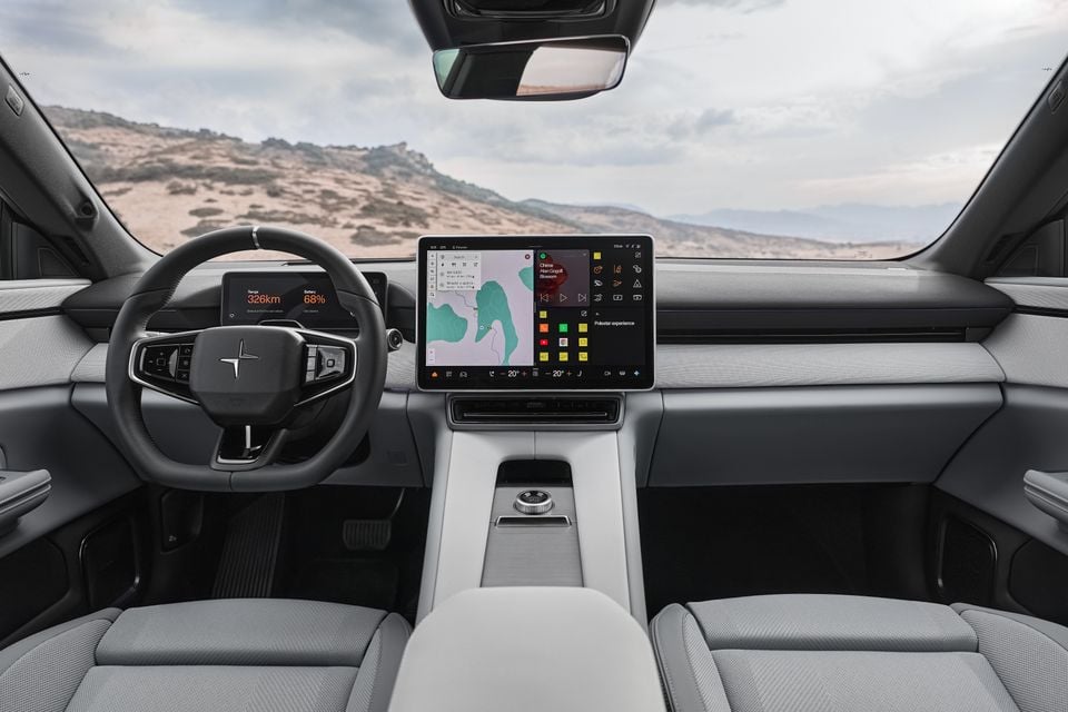 Dashboard of the 2027 Polestar 4 with a grey interior, steering wheel, digital driver display and large central touchscreen facing a desert landscape