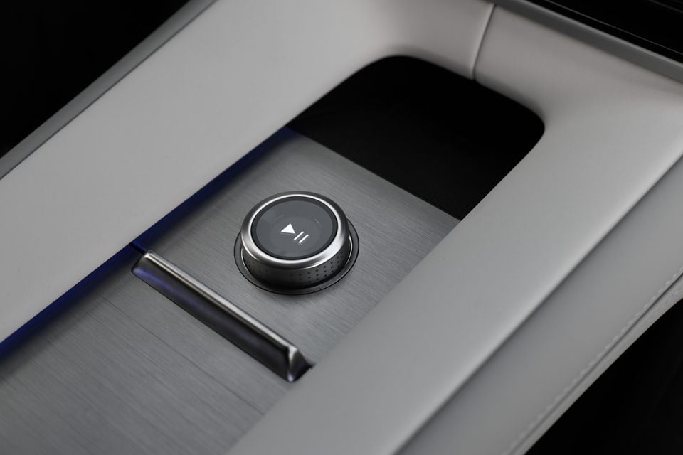 Rotary media control dial with play and pause symbol on the brushed metal centre console of a 2027 Polestar 4 SUV