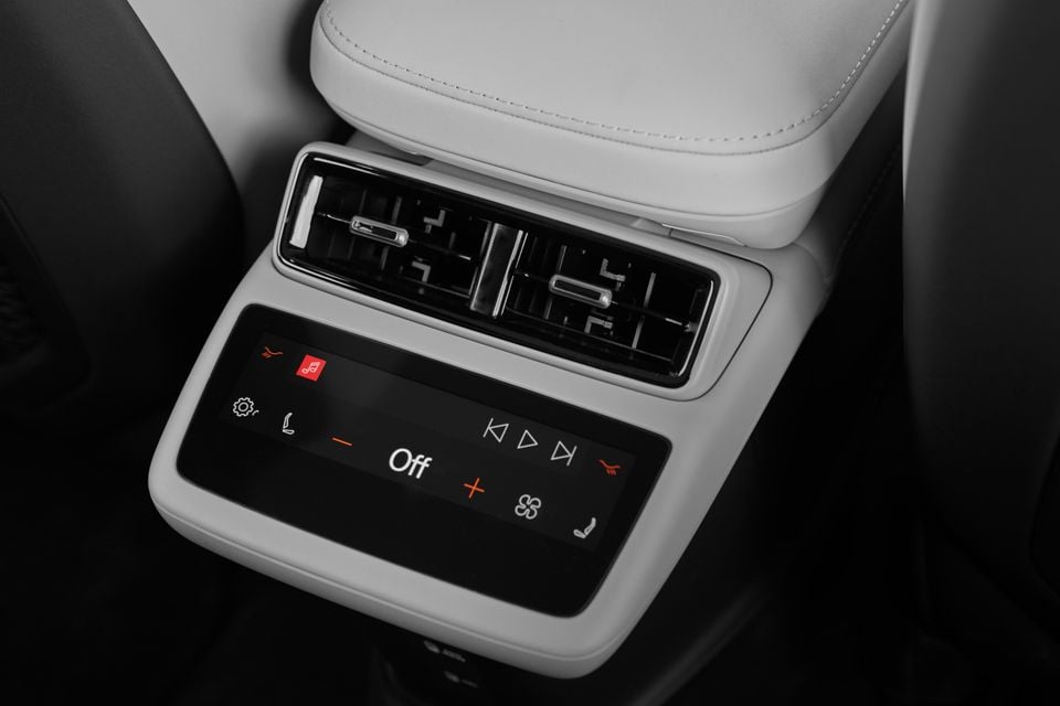 Rear climate control touchscreen and air vents below the centre armrest in a 2027 Polestar 4 SUV with light grey upholstery
