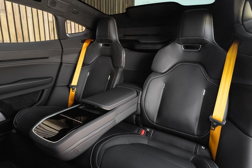 Rear seats of the 2027 Polestar 5 Performance in black leather with yellow seatbelts and a fold-down centre armrest with console