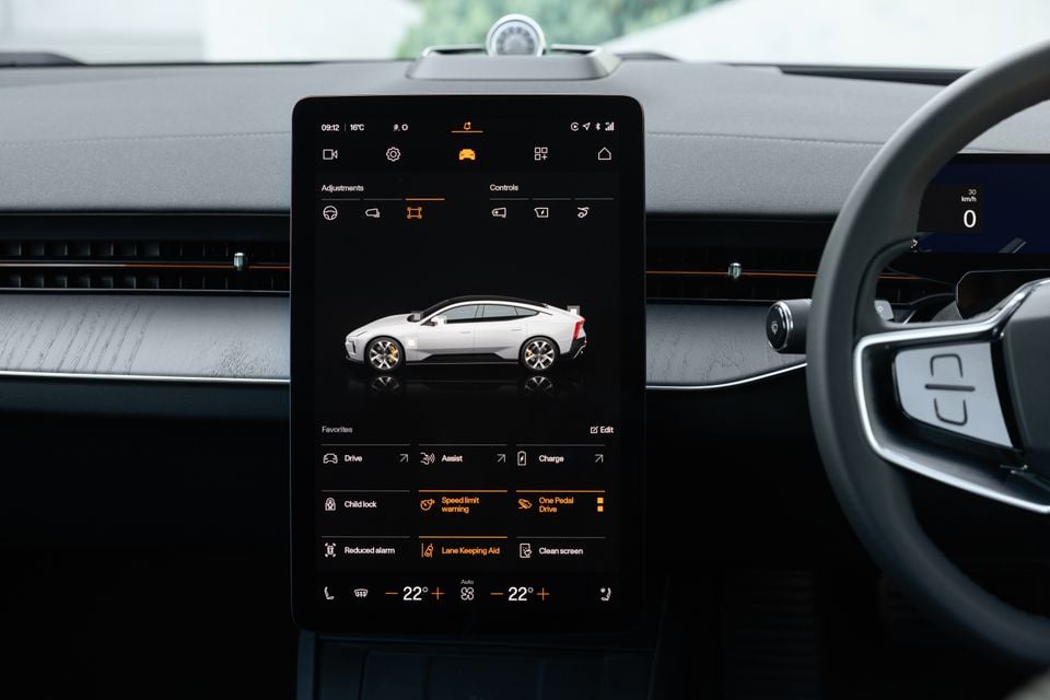 Portrait touchscreen in the 2027 Polestar 5 Performance dashboard showing vehicle settings and climate controls, beside the steering wheel
