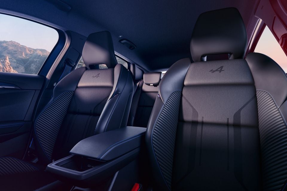 Front seats of the 2027 Renault Megane E-Tech Esprit Alpine with Alpine logos, blue stitching and a centre armrest, with the rear seats beyond