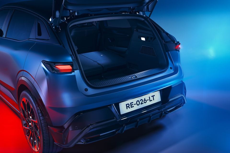 Rear of a dark blue 2027 Renault Megane E-Tech Esprit Alpine with its tailgate open, showing the boot with the rear seats folded flat