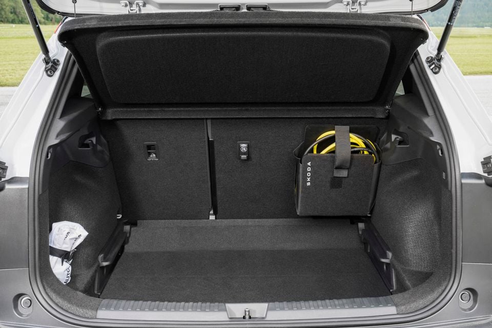 Boot of a Skoda Epiq with the tailgate open, showing a carpeted cargo area with a Skoda-branded charging cable bag and top-tether anchor points