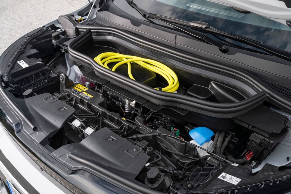 Engine bay of a Skoda Epiq with a yellow charging cable coiled near the firewall