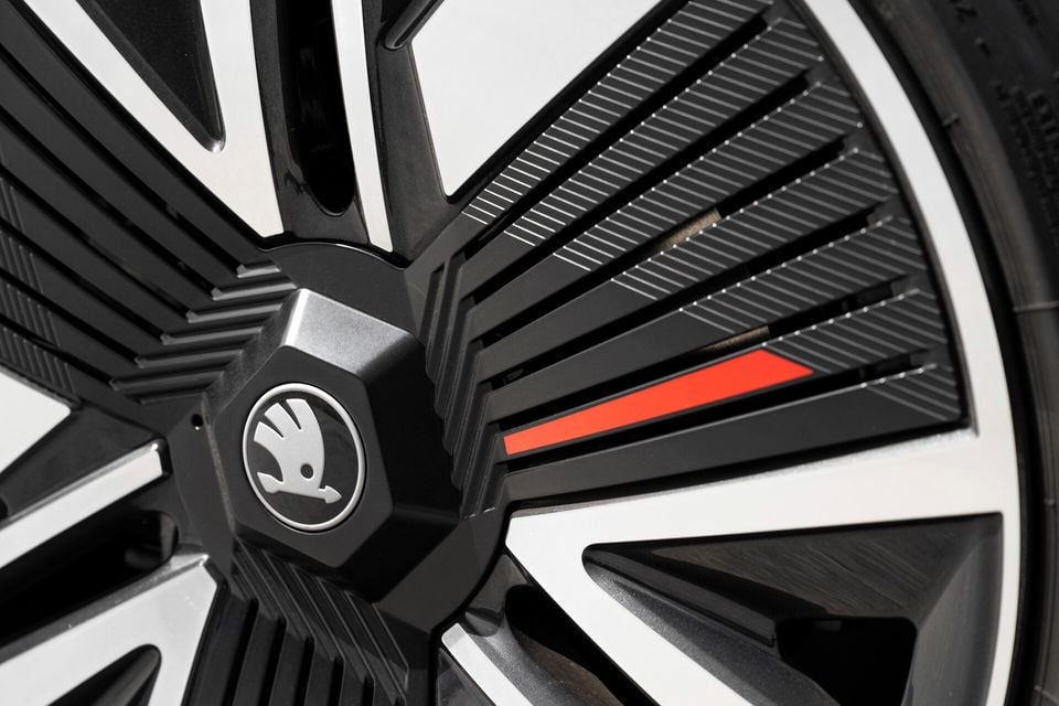 Close-up of a Skoda alloy wheel with black and silver multi-spoke design, red accent detail, and Skoda centre cap logo