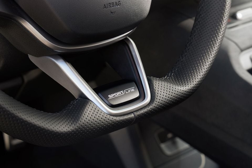 Close-up of a Skoda Sportline steering wheel badge on a leather-wrapped steering wheel
