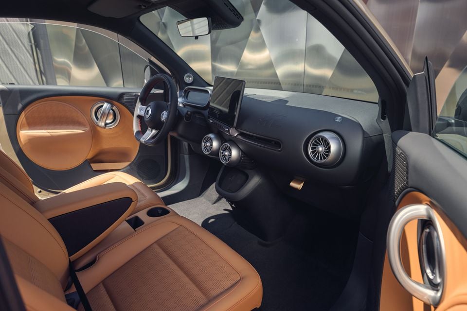 Interior of the 2027 smart #2 with tan leather seats, a black dashboard, round air vents, a steering wheel and a central touchscreen