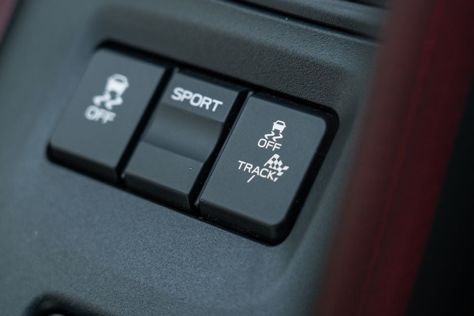 Close-up of driving mode buttons inside a Subaru BRZ tS, showing Sport, Track, and stability control off switches on the centre console