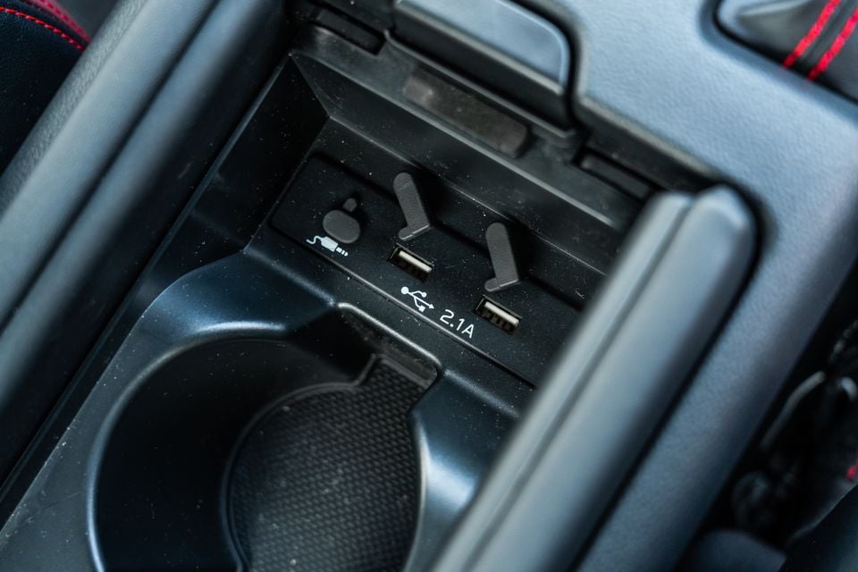 USB ports and aux input in the centre console of a Subaru BRZ, with a 2.1A charging port visible