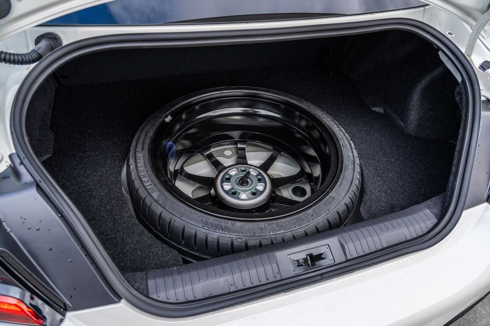 A spare wheel stored in the boot of a 2027 Subaru BRZ tS, viewed from the rear with the boot lid open