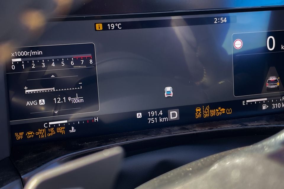 Digital instrument cluster display in a Subaru Outback Wilderness showing a rev counter, average fuel consumption of 12.1L/100km, trip distance, range, and driver assistance status indicators