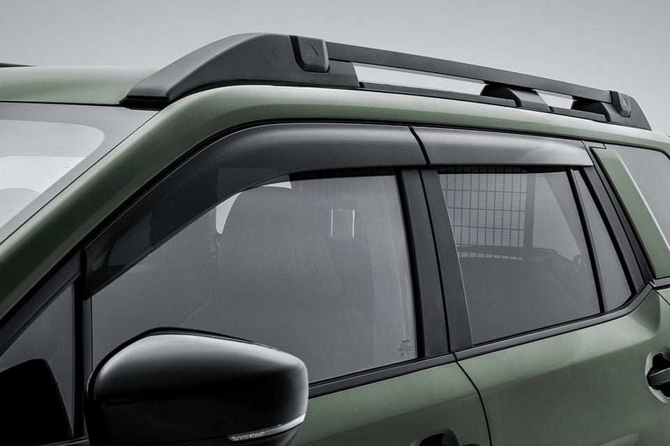 Close-up of a green Subaru Outback Wilderness showing door window weather shields and roof rails on the side of the vehicle