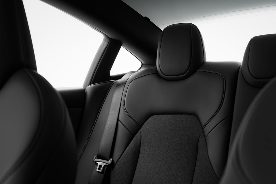 Close-up view of the black rear seat and seatbelt inside a Tesla Model 3