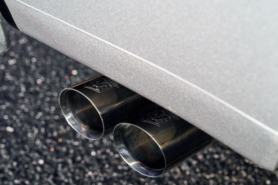 Close-up of the dual exhaust tips on a Volkswagen Amarok W600 by Walkinshaw, finished in dark metal against a silver rear bumper