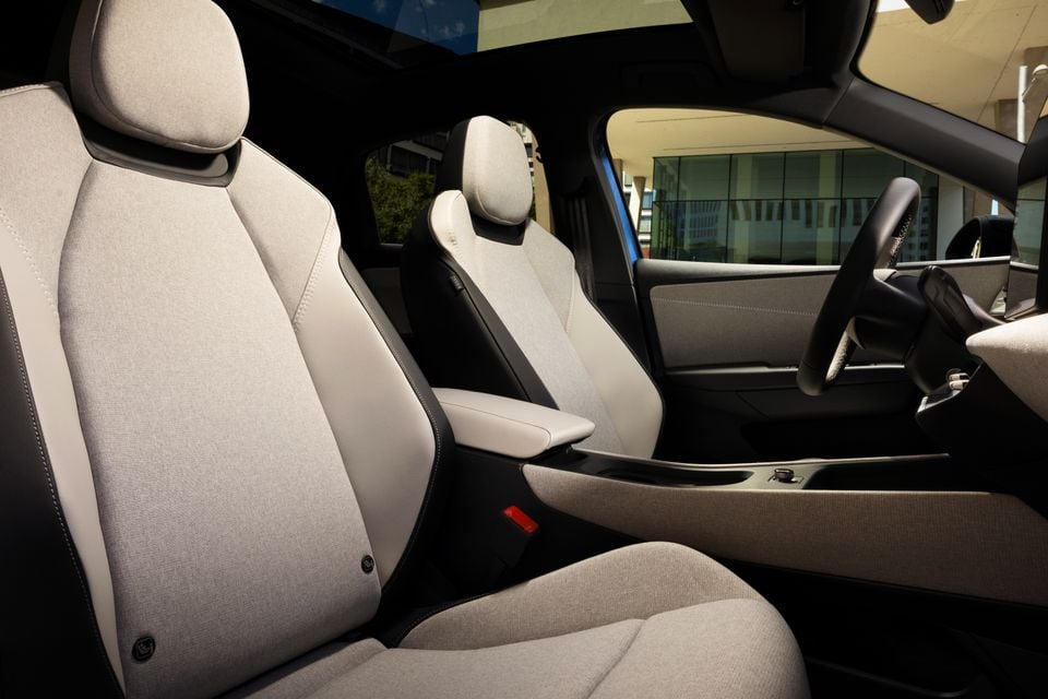 Interior view of a 2027 Volkswagen ID. Polo showing light grey fabric front seats, centre console, and steering wheel
