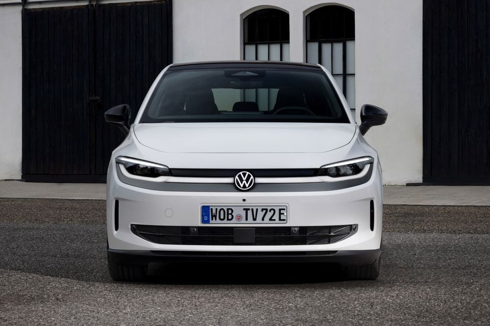 A white Volkswagen ID. Polo electric hatchback seen from the front, parked outside a white building