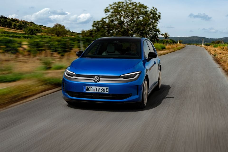 A blue Volkswagen ID. Polo hatchback seen from the front while driving on a rural road
