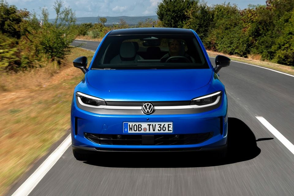 A blue Volkswagen ID. Polo seen from the front while driving on a country road