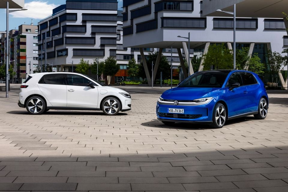 Two Volkswagen ID. Polo electric hatchbacks parked in an urban plaza, one in white seen from the side and one in blue seen from the front