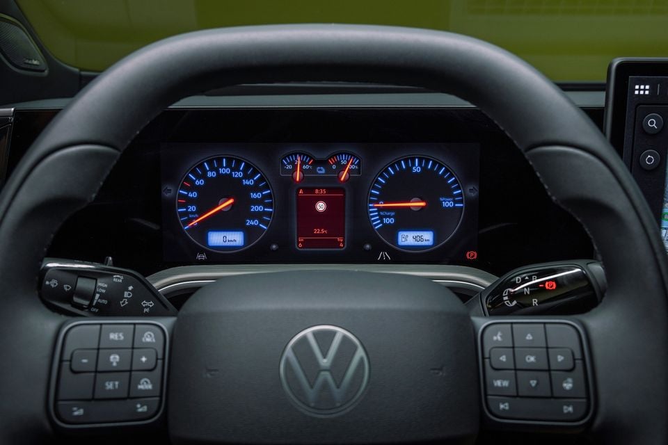 Steering wheel and retro-style digital instrument cluster in the 2027 Volkswagen ID. Tiguan, showing analogue-look speed and power dials.