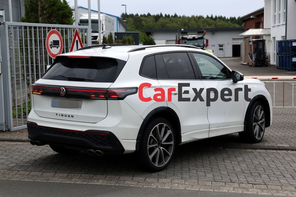 A white Volkswagen Tiguan R SUV seen from the rear three-quarter angle, parked in an industrial area