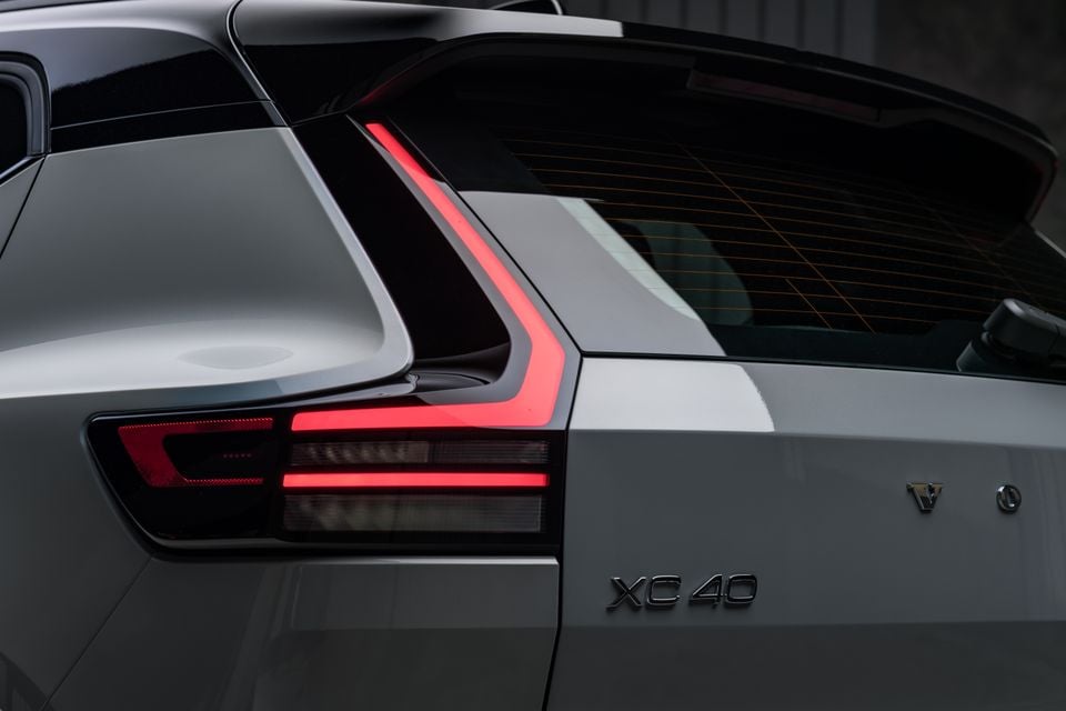 Close-up of the rear tail light and badging on a Volvo XC40, showing the XC40 model badge and Volvo logo on a grey body panel