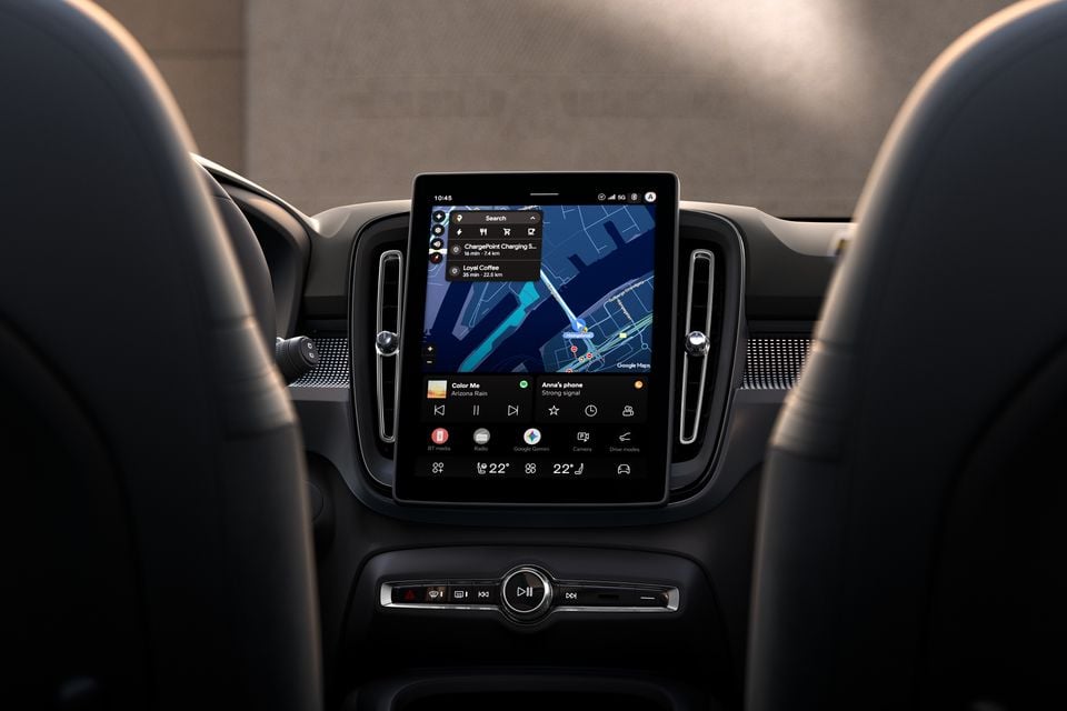 The vertical touchscreen infotainment system inside a Volvo EX40, showing Google Maps navigation, media controls, and climate settings