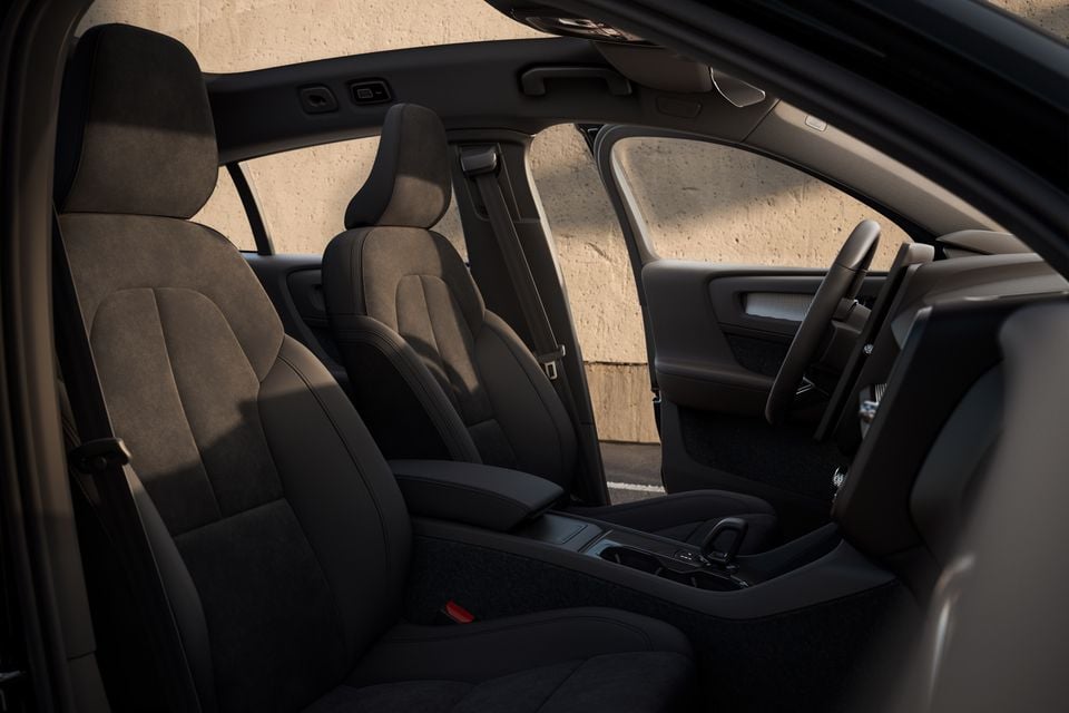 Interior view of a Volvo car showing dark alcantara front seats, centre console, and steering wheel