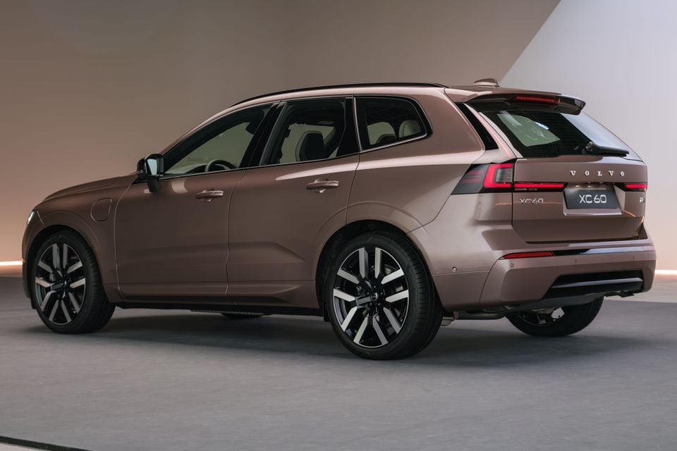 A bronze Volvo XC60 SUV seen from the rear three-quarter angle in a studio setting