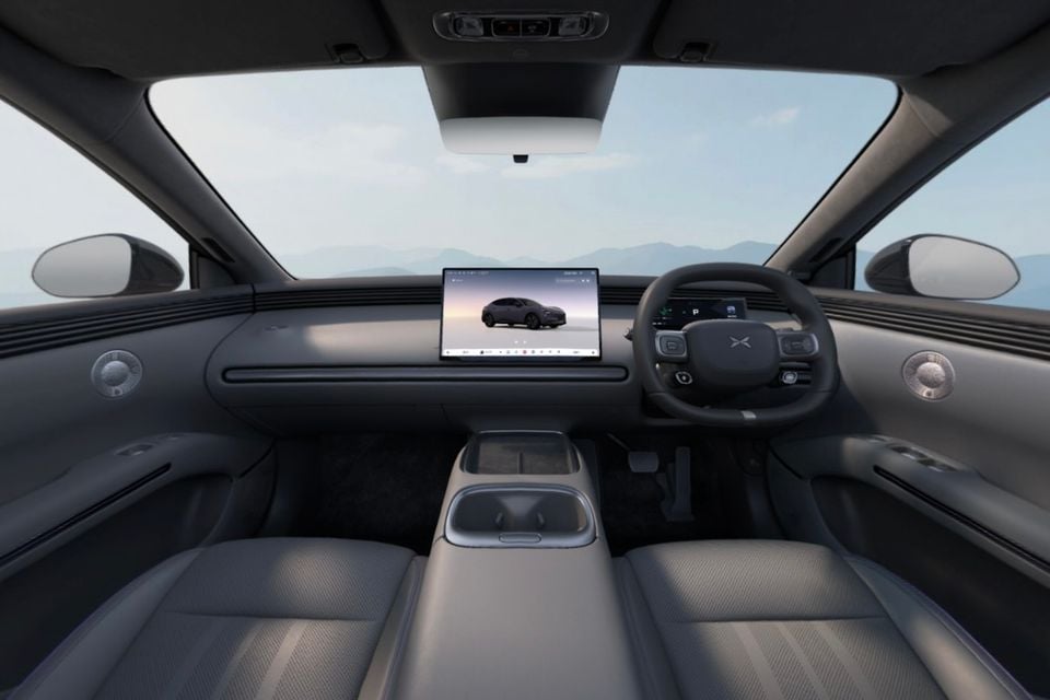 The dark grey interior of a 2027 Xpeng L03, viewed from the rear seats showing the dashboard, steering wheel and infotainment screen.