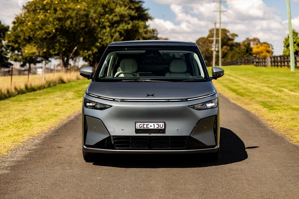 A grey 2027 Xpeng X9 electric MPV seen from the front, parked on a rural road in Australia.