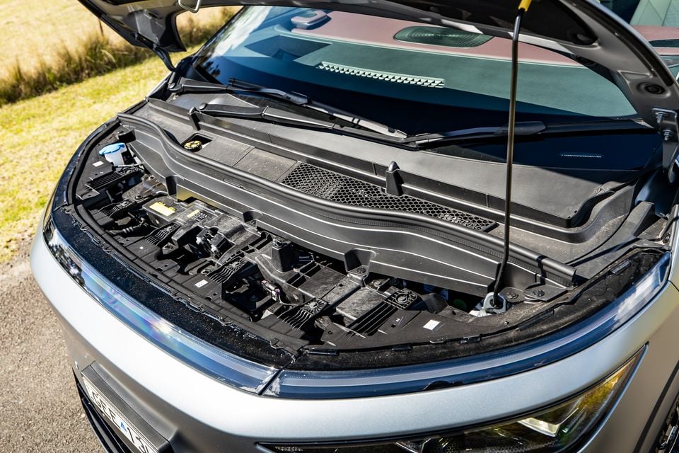 Open bonnet of a silver 2027 Xpeng X9 revealing the front compartment with electric drivetrain components