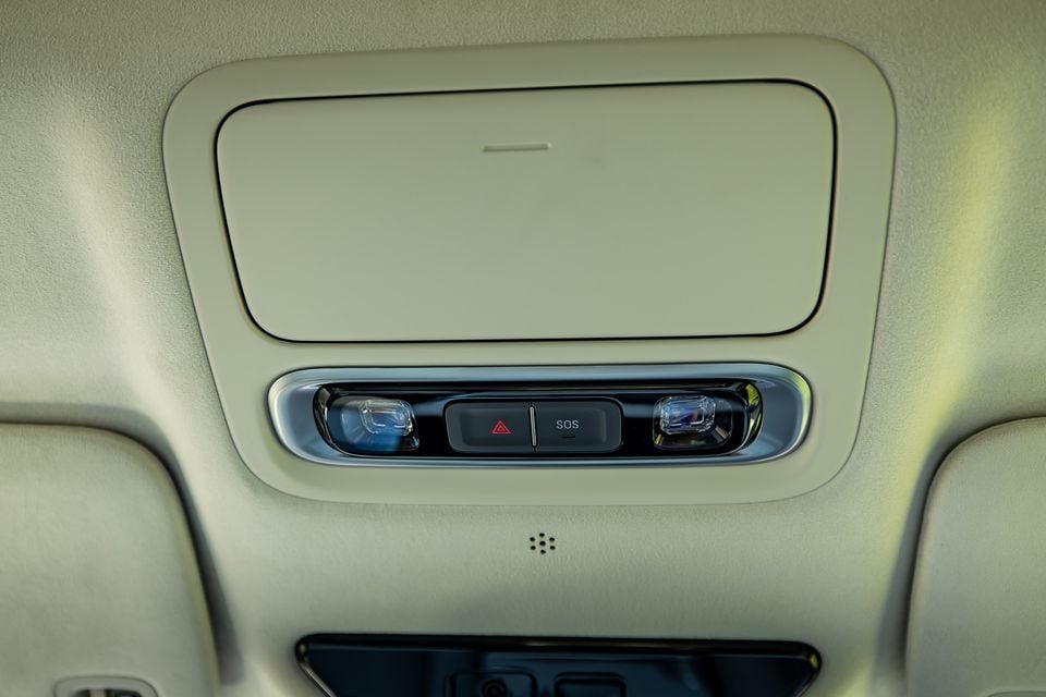 Interior roof console of the 2027 Xpeng X9 showing reading lights, an SOS button, and a hazard light button on the overhead headliner