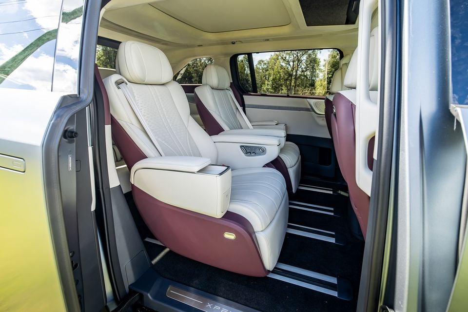Luxury cream and burgundy leather captain's chairs in the second row of an XPENG X9, viewed through the open sliding door