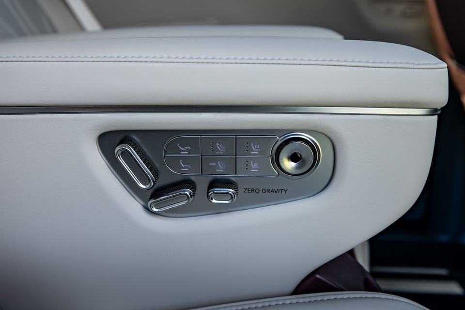 Close-up of the seat adjustment control panel on a 2027 Xpeng X9, featuring power seat controls, massage settings, and a Zero Gravity button on the white leather door trim.