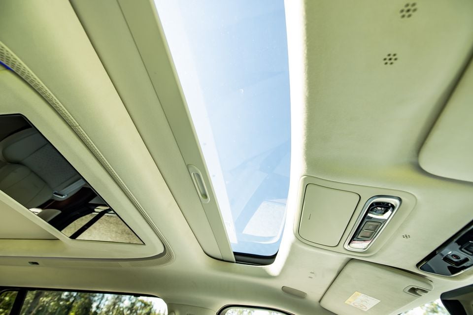 Interior roof lining of the 2027 Xpeng X9 showing a large panoramic sunroof open to the sky, with overhead controls and speaker grilles visible