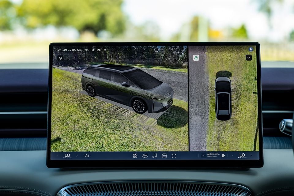 The touchscreen infotainment display in a 2027 Xpeng X9 showing a 3D surround-view camera system with a side angle and bird's-eye view of the vehicle.