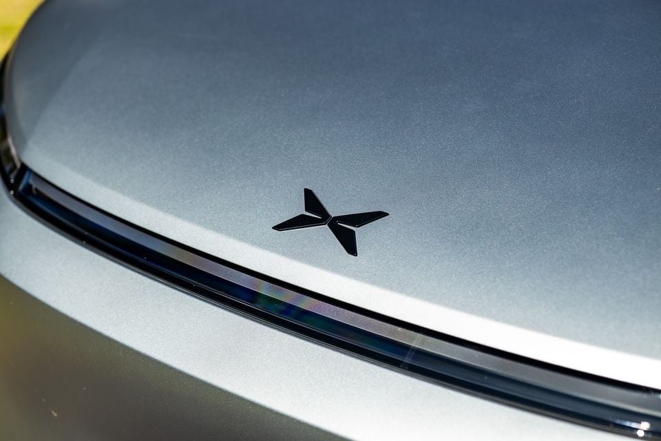 Close-up of the Xpeng logo badge on the bonnet of a grey Xpeng X9