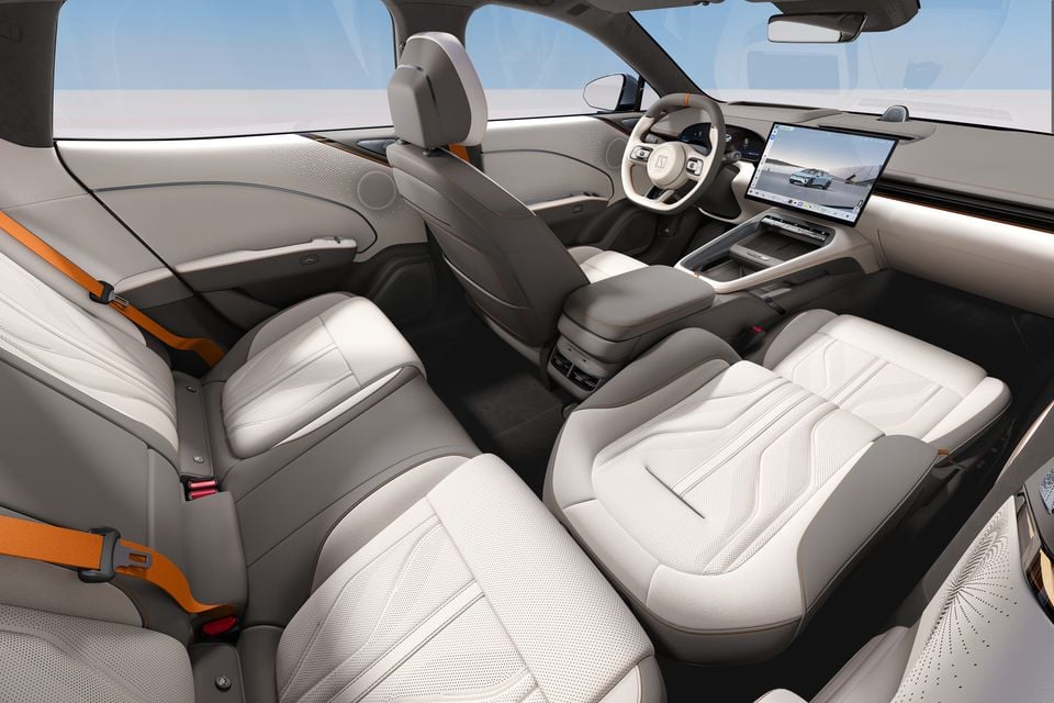 Interior of the 2027 Zeekr 7GT showing light grey leather seats, a large central touchscreen infotainment display, and orange seatbelt accents
