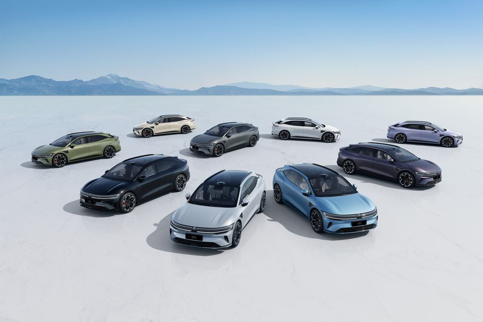 A lineup of Zeekr 7GT vehicles displayed in a circle on a salt flat, shown in various colours including green, black, white, grey, blue, dark purple and lavender.