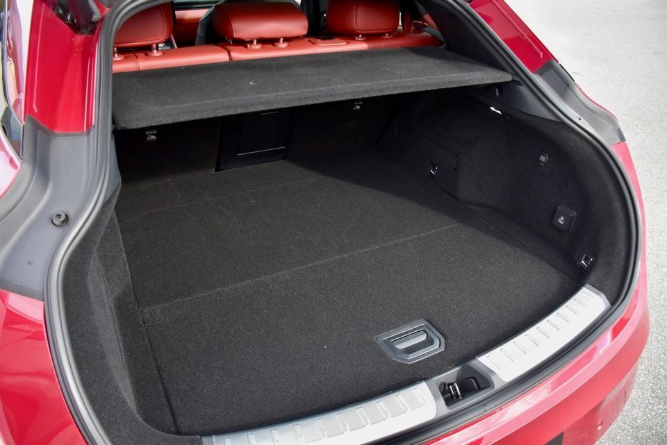The empty boot of a red Zeekr 7GT wagon with a cargo cover and red leather rear seats visible