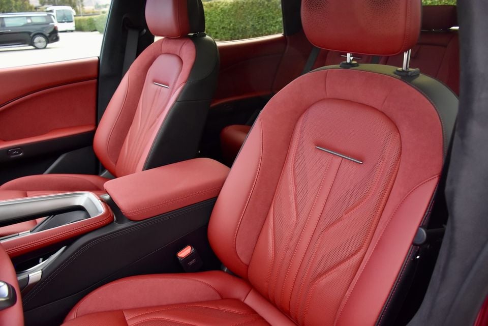 Red leather front seats with black trim and a centre armrest inside a Zeekr 7GT