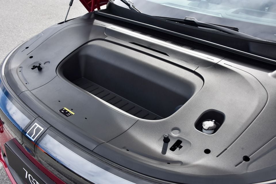 The open front storage compartment (frunk) of a Zeekr 7GT, showing the empty storage bin and underside of the bonnet